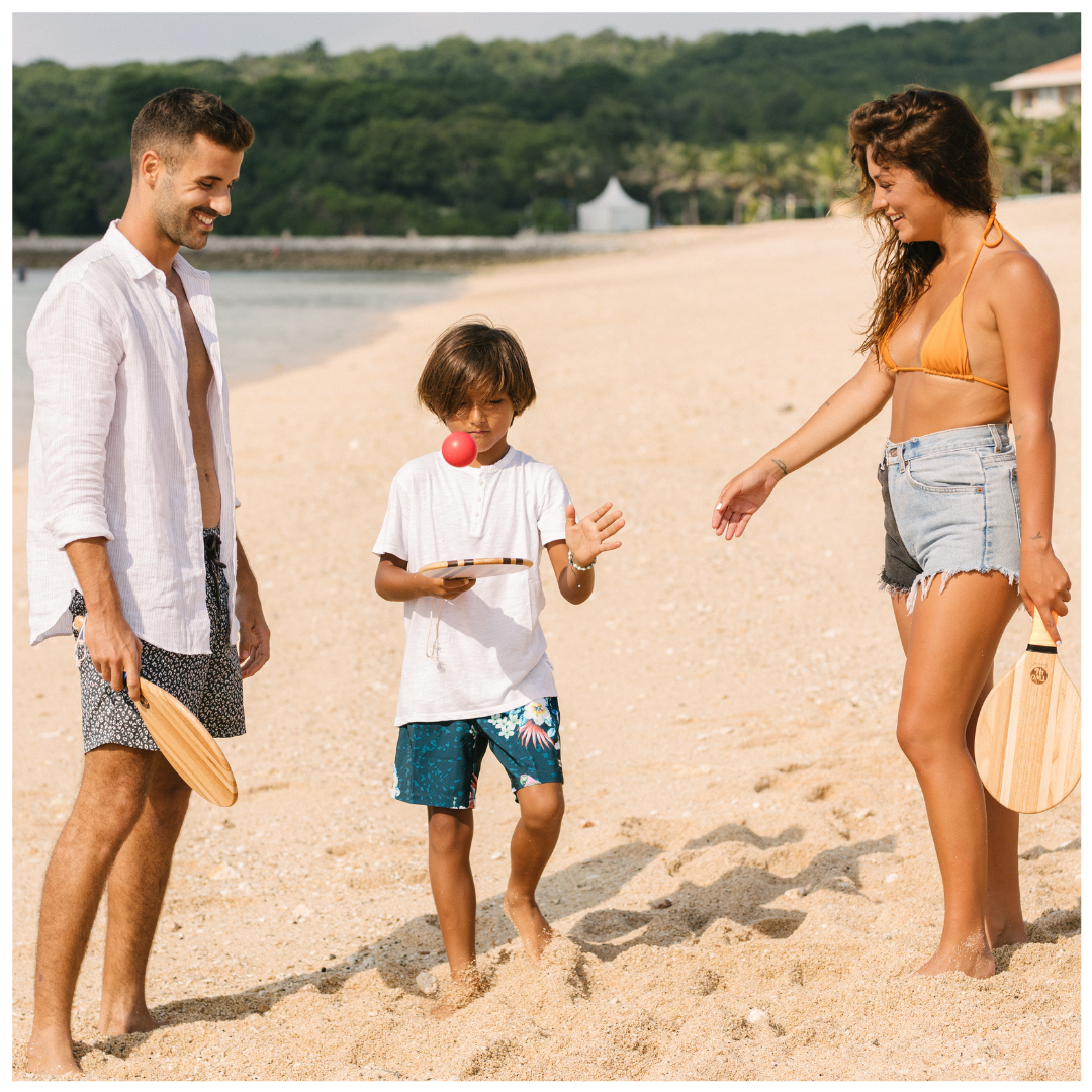 Frescobol - family playing with their wooden beach bats and balls on the beach