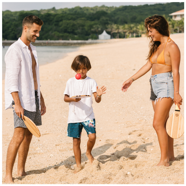 Frescobol - family playing with their wooden beach bats and balls on the beach